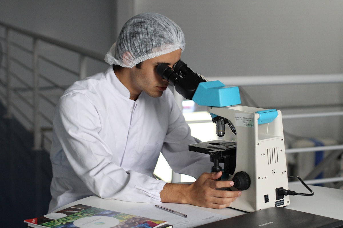 Biomédico olhando por microscópio