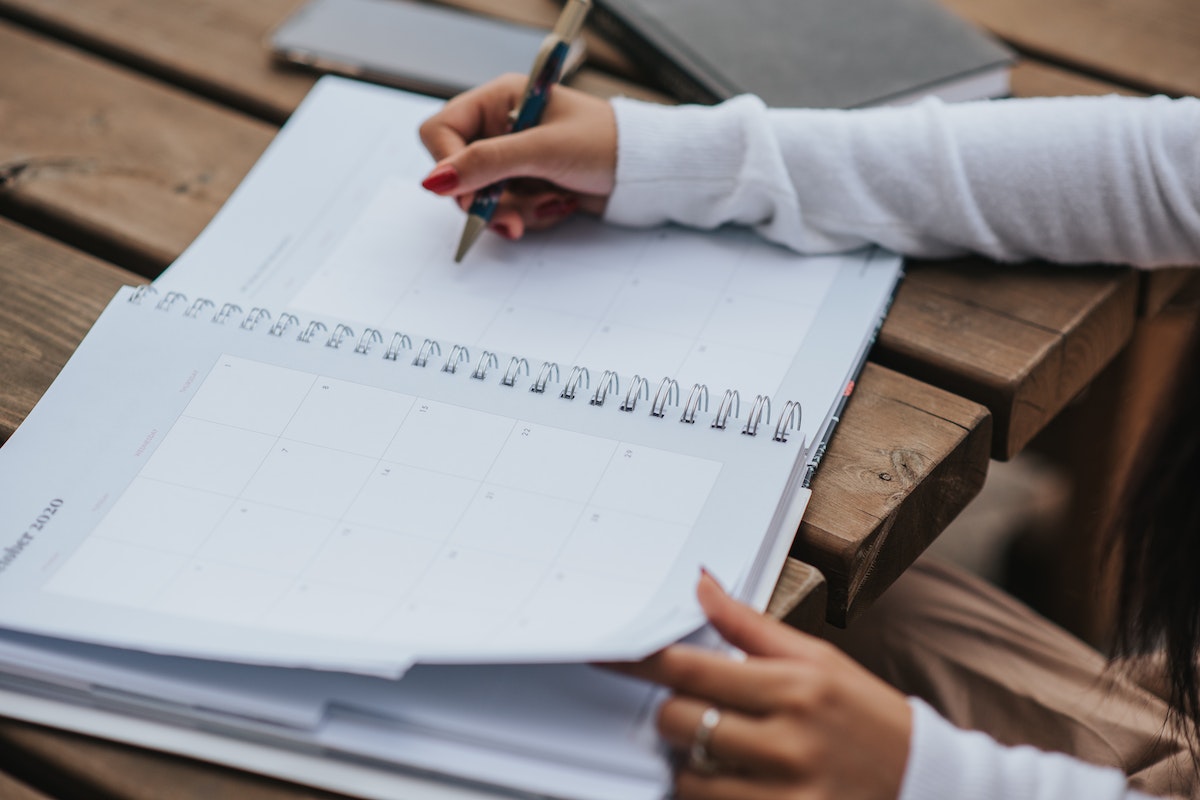 Uma estudante está escrevendo em seu caderno, foco apenas nos braços escrevendo