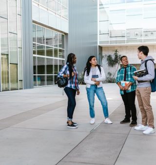 Um grupo de jovens estudantes estão em pé um aio lado do outros. São seis alunos que se preparam para o ENEM