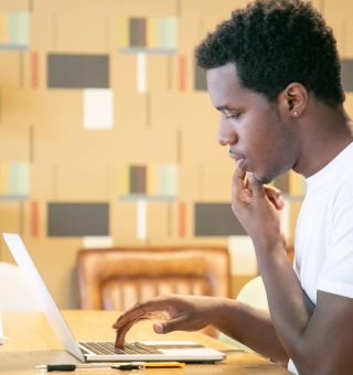 Estudante universitário negro usando o notebook