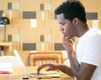 Estudante universitário negro usando o notebook