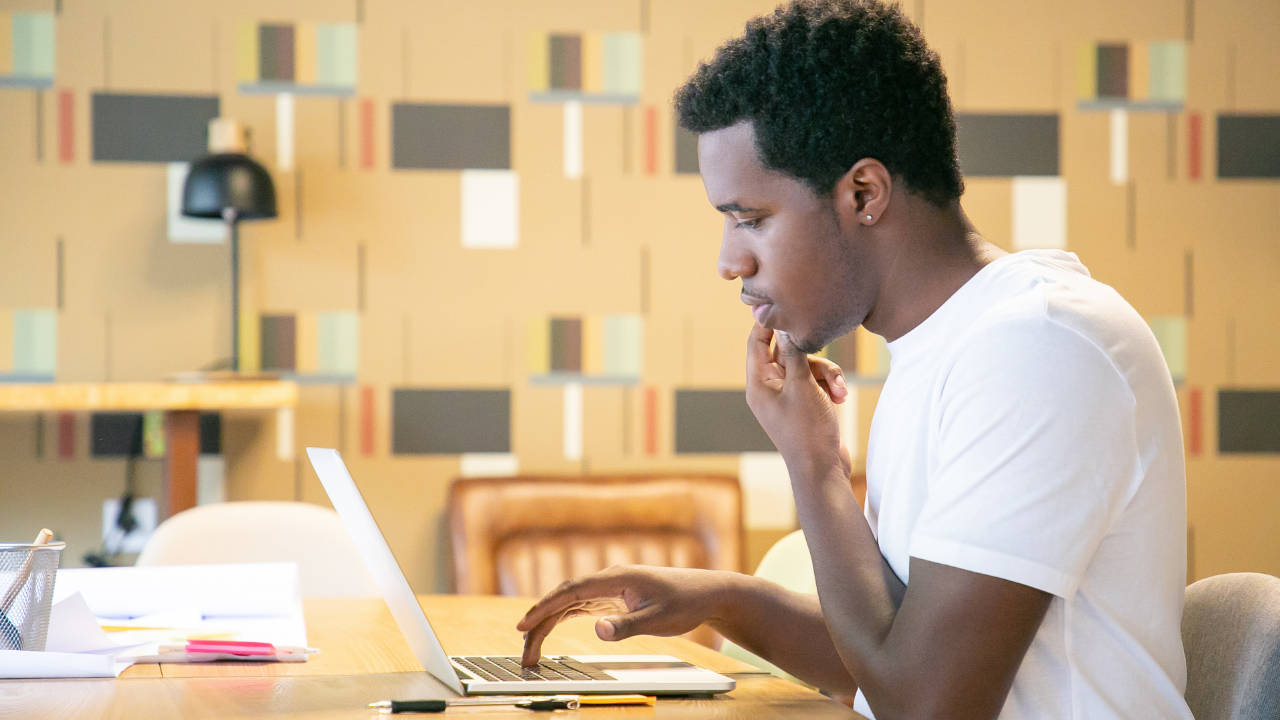 Estudante universitário negro usando o notebook
