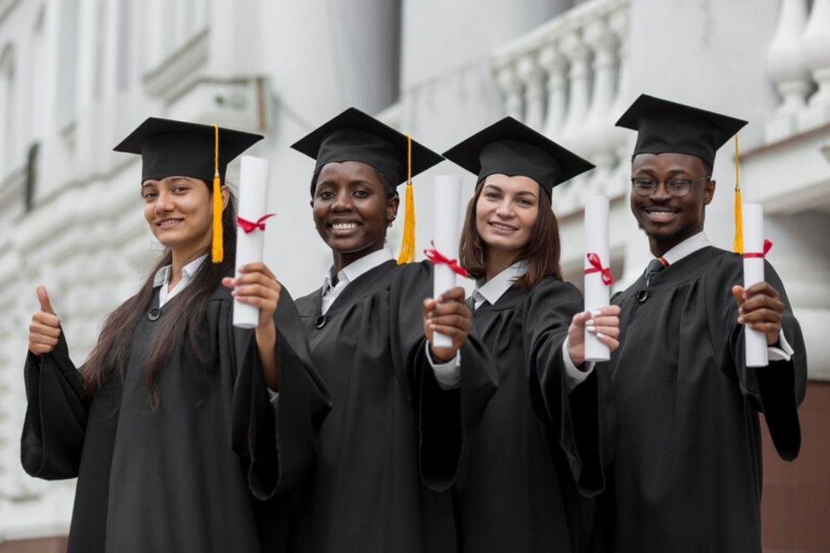 Quatro estudantes do Vestibular FDF 2024 seguram o diploma e usam beca de formandos
